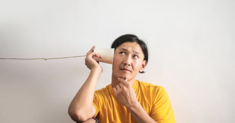 Music Experiences - Pensive ethnic man listening to answer in paper cup phone