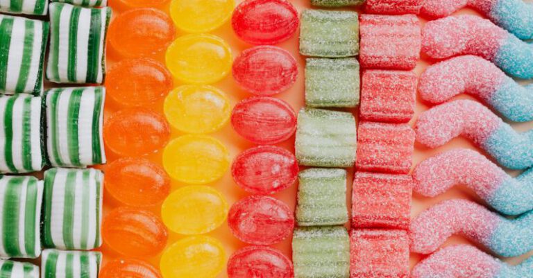 Event Types - From above of various delicious jelly and caramel sweets arranged in rows by type and color in modern candy store